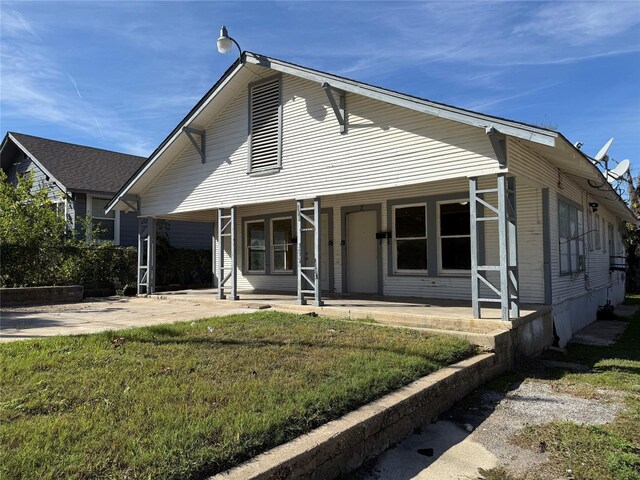 view of front of home with a porch and a front lawn