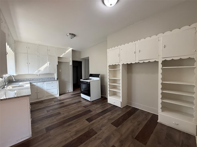 kitchen with sink, white gas stove, dark hardwood / wood-style floors, light stone countertops, and white cabinets