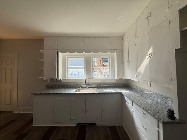 kitchen with sink, white cabinets, dark hardwood / wood-style floors, and dark stone counters