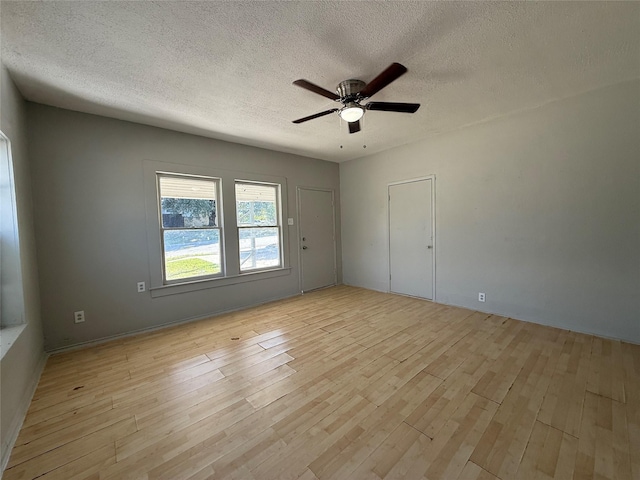 spare room featuring ceiling fan, light hardwood / wood-style flooring, and a textured ceiling