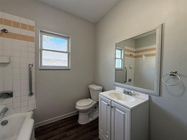 full bathroom with tiled shower / bath, vanity, toilet, and hardwood / wood-style floors