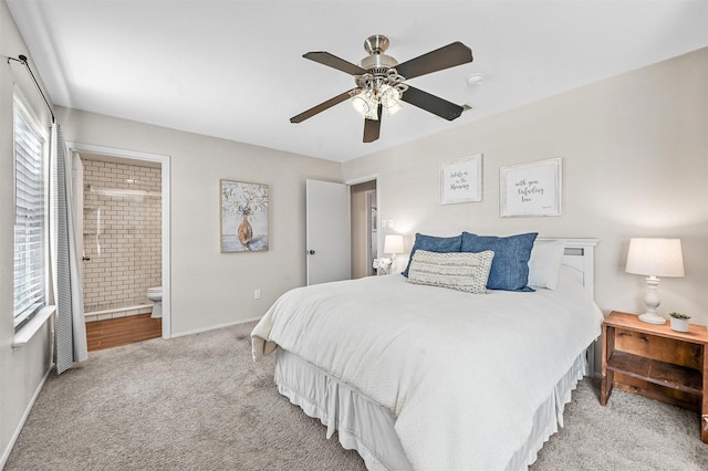 bedroom with ensuite bath, ceiling fan, and light colored carpet