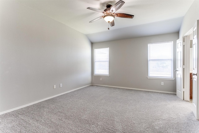 carpeted spare room featuring lofted ceiling, plenty of natural light, and ceiling fan