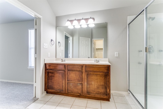 bathroom with a shower with door, vanity, and tile patterned floors