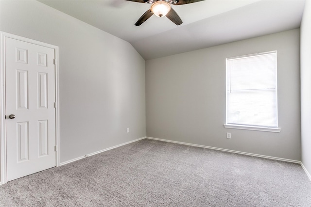 carpeted empty room with ceiling fan and vaulted ceiling