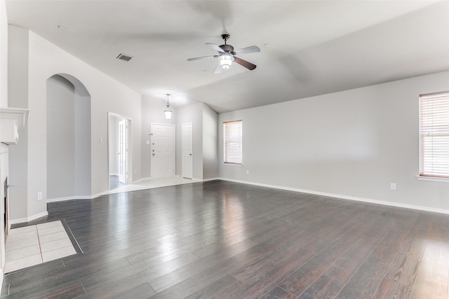 unfurnished living room with ceiling fan, vaulted ceiling, and dark hardwood / wood-style flooring