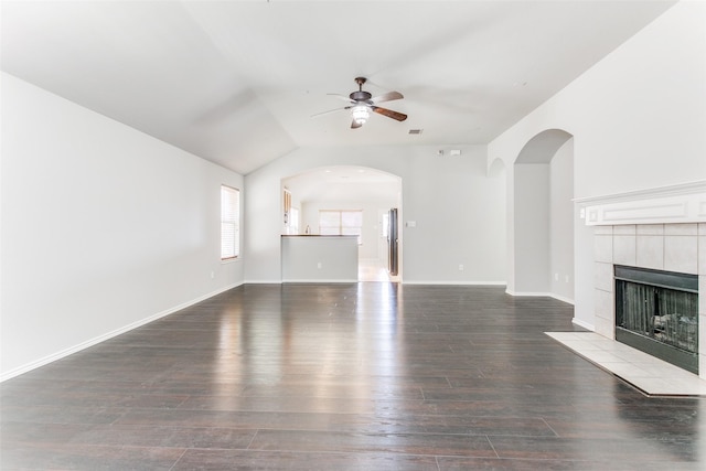 unfurnished living room featuring ceiling fan, a fireplace, dark hardwood / wood-style flooring, and vaulted ceiling