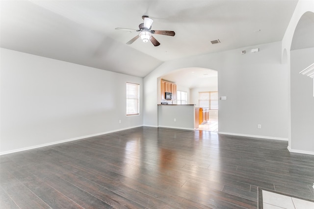 unfurnished living room featuring ceiling fan, vaulted ceiling, and dark hardwood / wood-style flooring