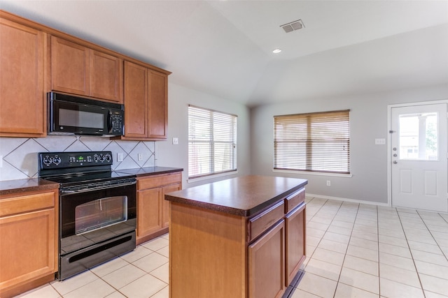 kitchen featuring light tile patterned flooring, lofted ceiling, backsplash, a center island, and black appliances