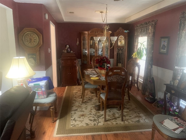 dining room with light hardwood / wood-style flooring and an inviting chandelier