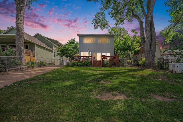 back house at dusk with a lawn