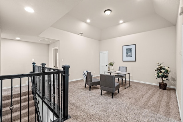 carpeted office space with a tray ceiling