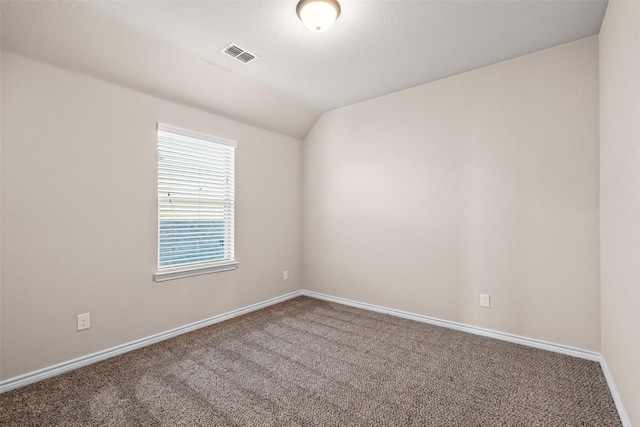 unfurnished room featuring lofted ceiling and carpet floors