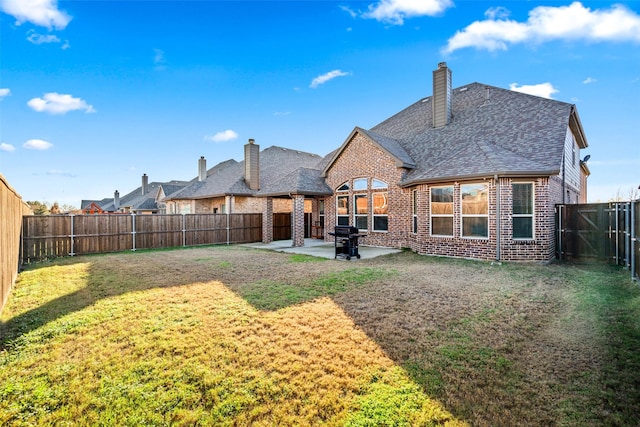 back of house with a lawn and a patio area