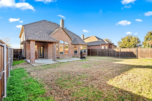 back of property with a lawn and a patio