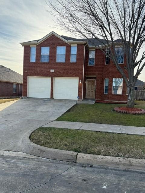 view of front of house featuring a garage and a front lawn