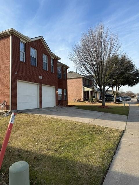 view of side of home with a garage and a lawn