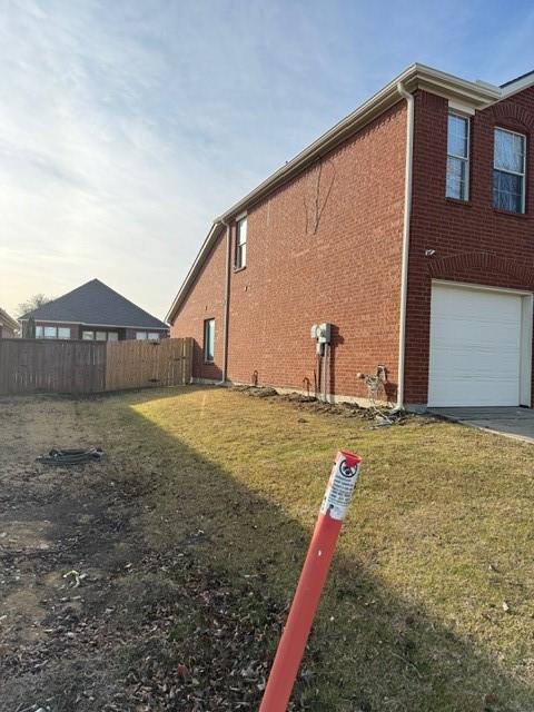 view of side of property with a yard and a garage