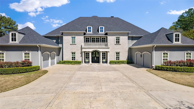 french provincial home featuring a balcony, a garage, and a front lawn