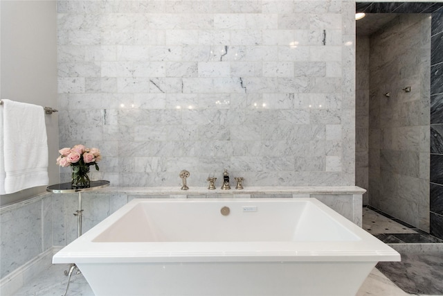 bathroom featuring a bath and tile walls