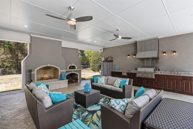 view of patio / terrace featuring a tile fireplace, sink, area for grilling, and a grill