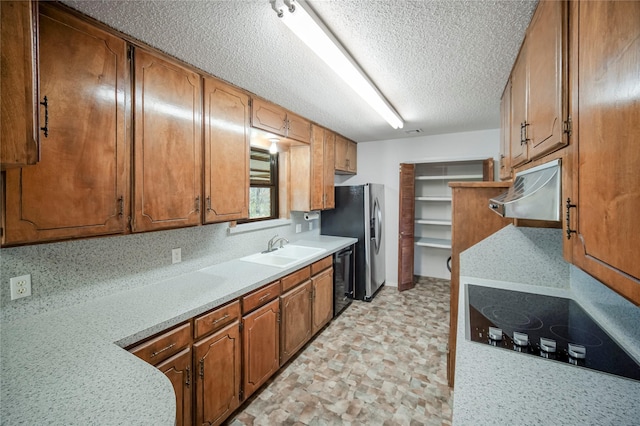 kitchen featuring a textured ceiling, black dishwasher, sink, and electric stovetop