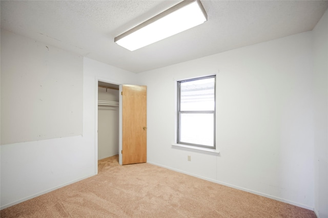 unfurnished bedroom featuring light colored carpet and a closet