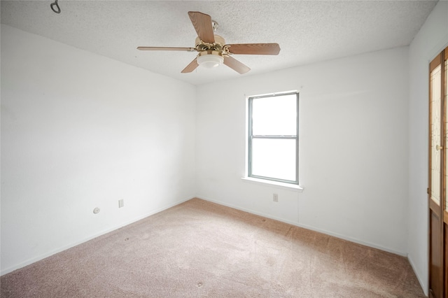 carpeted empty room featuring ceiling fan and a textured ceiling