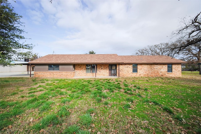 single story home featuring a front lawn and a carport