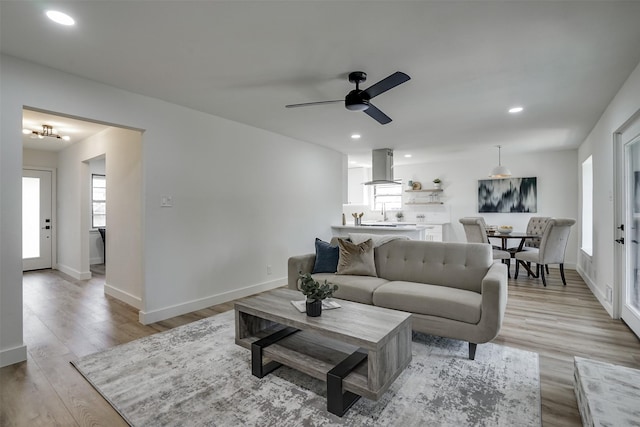 living room with light hardwood / wood-style flooring and ceiling fan