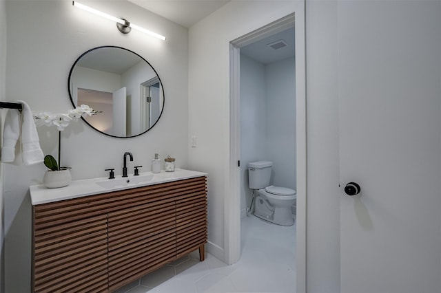 bathroom with tile patterned flooring, vanity, and toilet