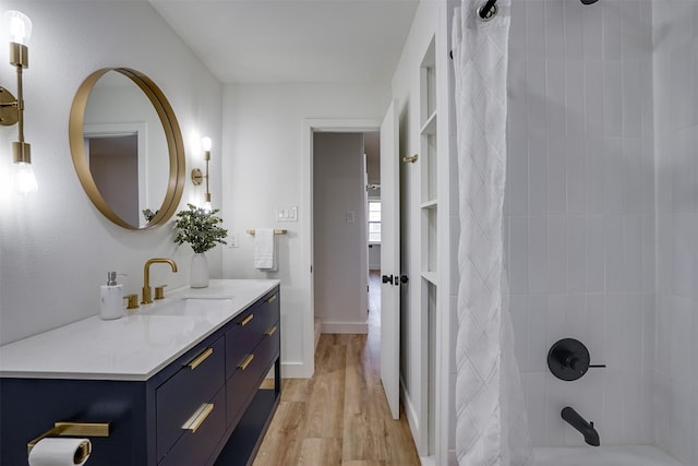 bathroom with hardwood / wood-style floors, vanity, and shower / bathtub combination with curtain