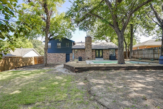 rear view of property featuring a lawn, a fenced in pool, central air condition unit, and a patio