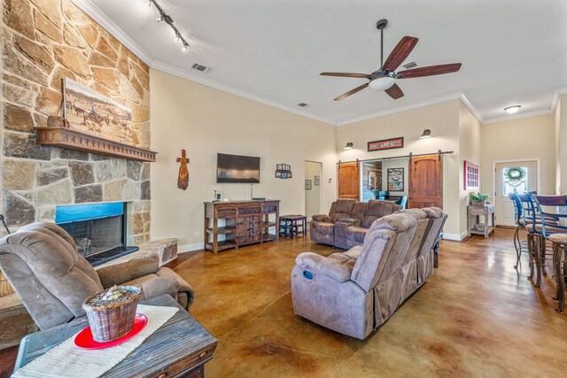 living room with concrete flooring, a barn door, track lighting, and ceiling fan