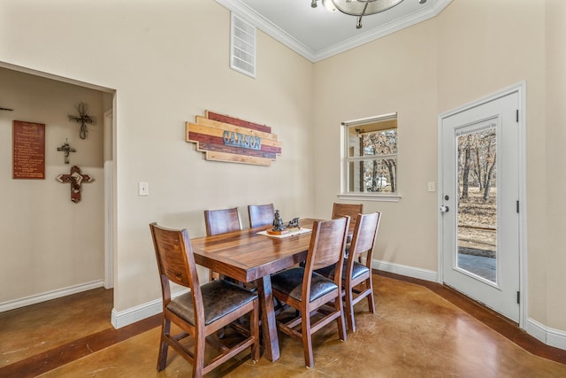 dining room with concrete floors and crown molding