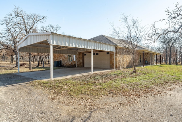 view of side of home featuring a carport, cooling unit, a garage, and a lawn