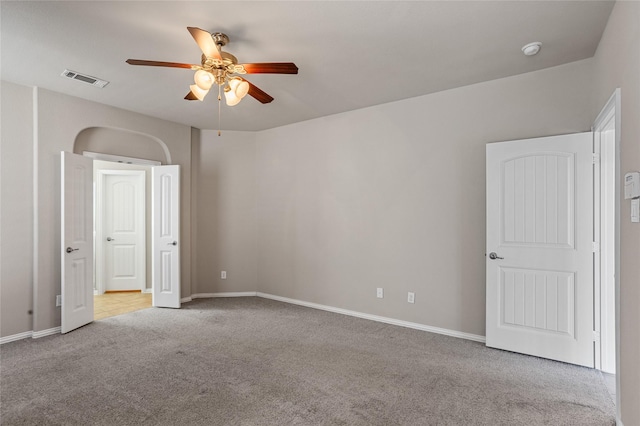 carpeted spare room with ceiling fan