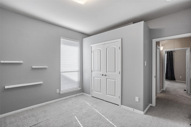 unfurnished bedroom featuring a closet and light colored carpet