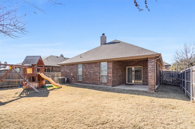 rear view of property featuring a playground, central AC unit, and a patio area