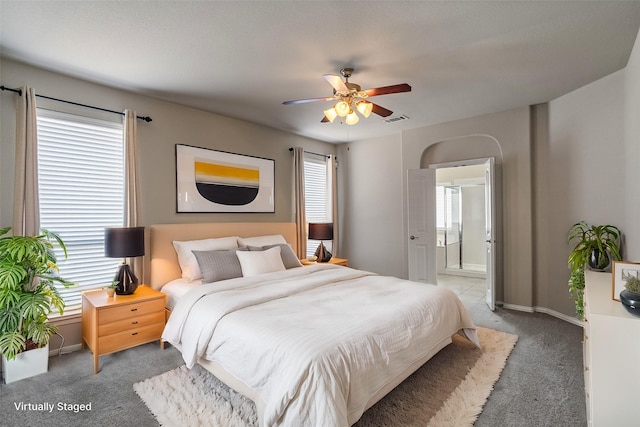 bedroom with ceiling fan, connected bathroom, and carpet