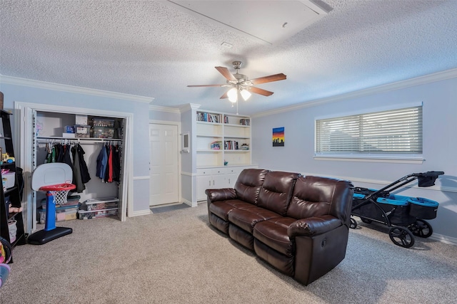 living room with ornamental molding, carpet, ceiling fan, a textured ceiling, and built in shelves