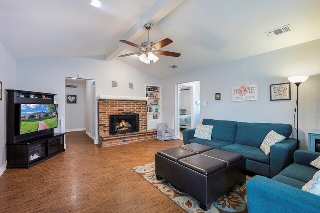 living room featuring vaulted ceiling with beams, wood-type flooring, a brick fireplace, built in features, and ceiling fan