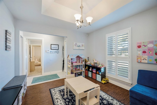 recreation room with dark wood-type flooring and an inviting chandelier