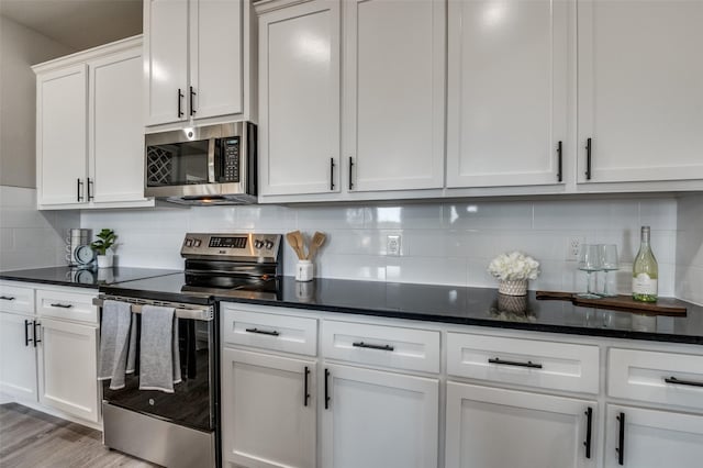 kitchen featuring stainless steel appliances, white cabinetry, tasteful backsplash, and light hardwood / wood-style floors