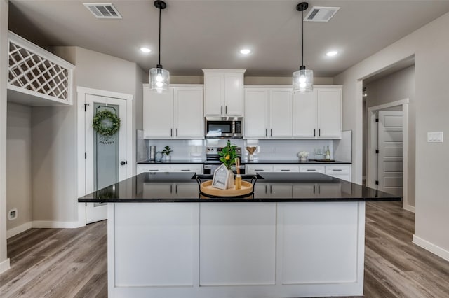 kitchen featuring white cabinetry, a kitchen island with sink, and appliances with stainless steel finishes