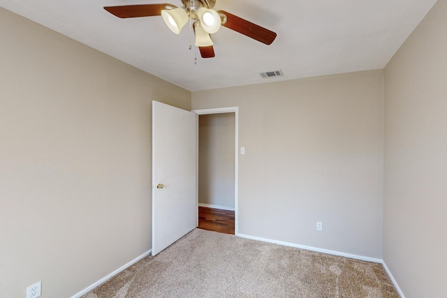 carpeted spare room with ceiling fan