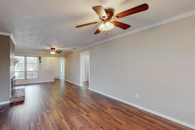 empty room with a fireplace, ceiling fan, crown molding, and dark wood-type flooring