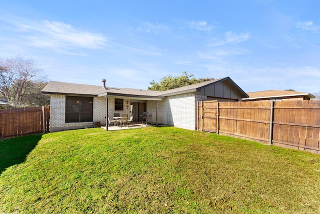 back of house featuring a lawn and a patio