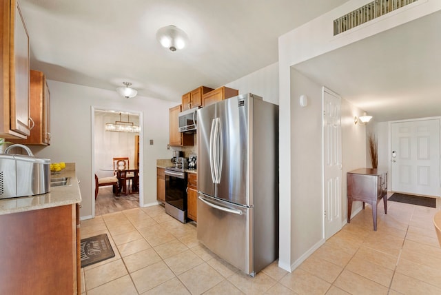 kitchen with sink, light tile patterned flooring, and appliances with stainless steel finishes