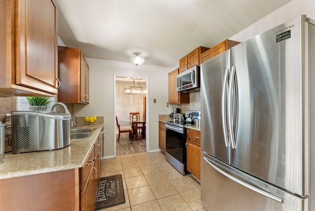 kitchen featuring light stone countertops, light tile patterned floors, and stainless steel appliances